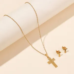 Detail of golden cross jewelry set with Greek meander patterns on white podium