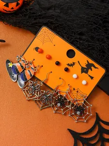 Dettaglio del set di orecchini di Halloween con cappelli da strega e ragni su carta arancio