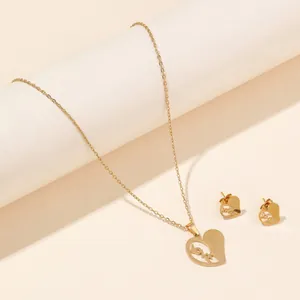 Detailed close-up of golden stainless steel heart jewelry set with love engraving