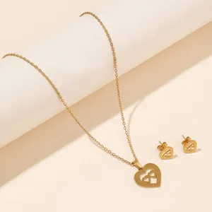 Detail view of heart-shaped pendant necklace and earrings set in polished gold finish