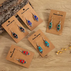 Bohemian retro alloy earrings set with turquoise inlay in various colors on wood background