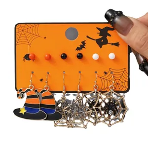 Set di orecchini di Halloween con cappelli da strega e ragni su cartoncino arancio
