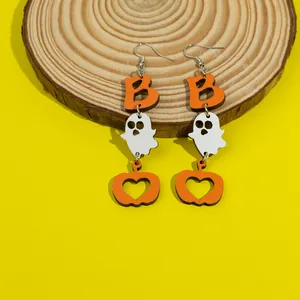 Detail of Halloween earrings featuring orange B letter, ghost, and pumpkin on wood