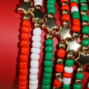 Macro detailopname van kerst kralenarmbanden met feestelijke rode groene parels en gouden sterren