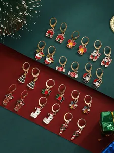 Detailed set of 12 Christmas hoop earrings with enamel charms on festive background