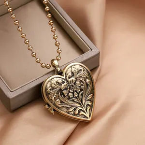 Pendentif cœur vintage avec gravure florale et chaîne à billes sur fond de soie