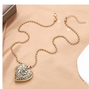Collier médaillon coeur doré vintage avec relief floral et chaîne à boules sur soie