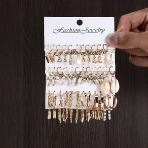 Detailed view of vintage gold earring set with pearls and geometric pendants on card