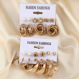 Detail of vintage gold earring set with pearls and butterfly studs on satin background