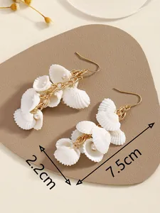 Detalle de pendientes de borla de nácar que muestra dimensiones de 7,5 cm de largo y 2,2 cm