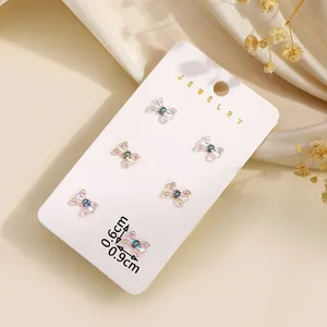 Detailweergave van zes kleurrijke hars strik oorknopjes op een sieraden display