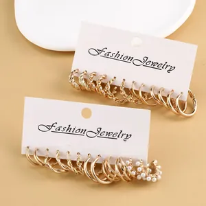Detail of vintage gold earrings set with pearls on a fashion jewelry display card