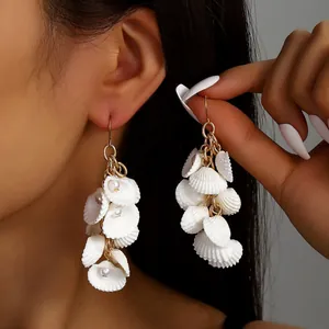 Elegantes pendientes largos de concha con capas blancas en abanico y ganchos dorados