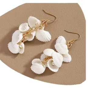 Pendientes largos de borla dorada con conchas blancas y perlas elegantes