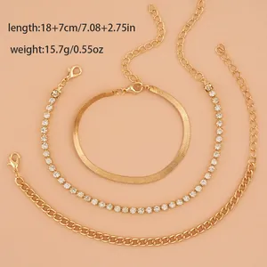Close-up of a 3-piece gold-tone bracelet set including snake, tennis, and figaro chain links