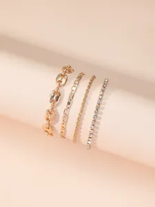 Detail of four-piece gold bracelet set with twisted rope, tennis and link chain styles