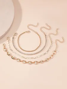 Close-up of four-piece gold bohemian bracelet set featuring rope and rhinestone chains