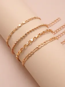 Detailed view of four-piece gold chain bracelet set including Figaro and box styles