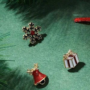 Detail of Christmas brooches with snowflake, gift box, and golden bells on pine branches
