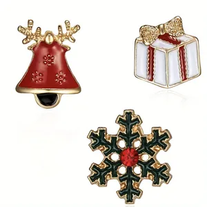 Detail of Christmas enamel pins featuring gold reindeer bell, gift box, and green snowflake
