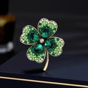 Broche trèfle exquise avec cristaux verts sur un coffret de présentation de luxe