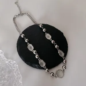Collana con perline d'argento e pietre preziose su vassoio di pietra nera