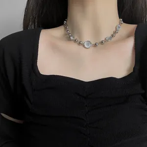 Collana minimalista con perline d'argento e pietre bianche su top nero elegante