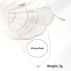 Elegant gold heart pendant necklace in stainless steel on a pearl shell display tray