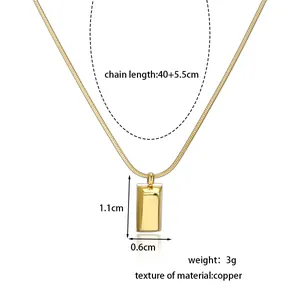 Gold rectangular pendant necklace made of copper with snake chain shown on white background