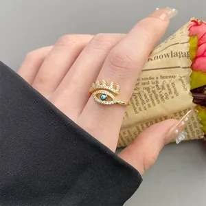 Adjustable evil eye ring with white zircon stones and blue bead on a female model