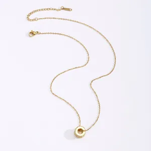 Elegante gouden titanium stalen ketting met cilinder hanger met zirkoon op witte achtergrond