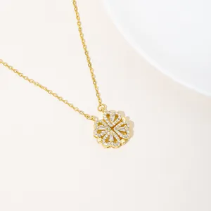 Detailopname van gouden klaver hanger ketting met gezette kristallen op zandgrond