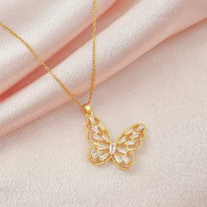 Primer plano de collar con colgante de mariposa dorada y circonitas sobre seda rosa
