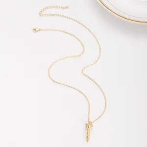 Collier minimaliste avec pendentif clou doré et zircons sur fond blanc épuré
