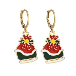 Dettaglio di orecchini natalizi festivi con design a scatola regalo in smalto rosso e verde