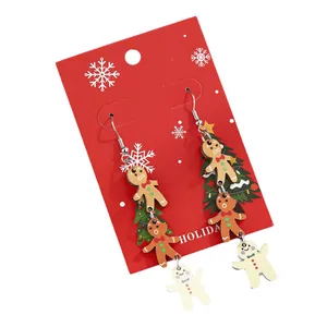 Christmas gingerbread man drop earrings with three-layer design on festive red card