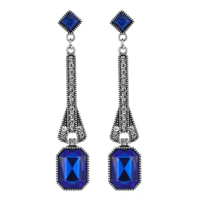 Detail of vintage teardrop earrings with blue gemstones and long tassel pendants