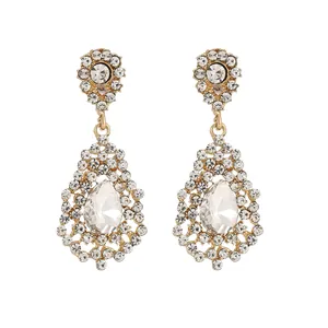 Detail of vintage gold drop earrings with pear-cut gemstones and sparkling rhinestones