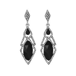 Macro shot of silver-tone drop earrings with faceted black gems and sparkling rhinestones