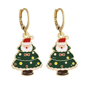 Dettaglio di orecchini smaltati dorati con ciondoli a Babbo Natale e albero di Natale