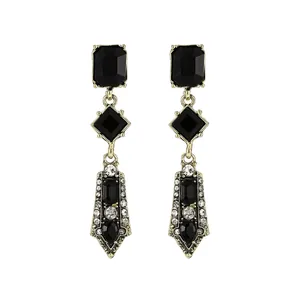Detail of vintage gold-tone drop earrings with black geometric gems and sparkling rhinestones