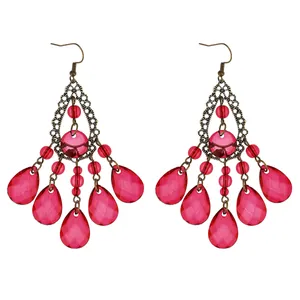 Macro detail of bohemian chandelier earrings with rose red beads and bronze filigree