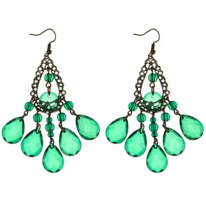 Detailed close-up of bohemian water drop earrings with green crystal and bronze metal