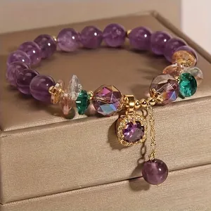 Elegante bracciale di perle viola con ciondoli in zirconia e nappa dorata