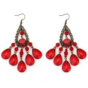 Detailed view of bohemian bronze chandelier earrings with red faceted beads and teardrops
