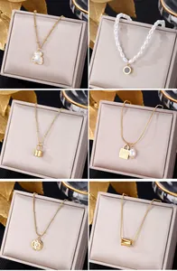 Detail showing six assorted gold necklaces with elegant charms on jewelry boxes