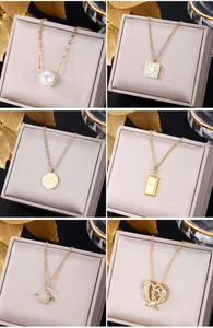 Detail view of six gold necklaces featuring pearl, heart, eye, and planet charms on gray stands
