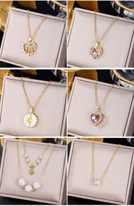 Selection of six gold necklaces with emerald and crystal pendants on jewelry box