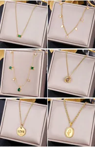 Detail of six gold necklaces featuring emerald pendants and engraved round charms
