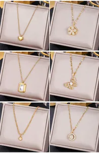 Detailed close-up of six gold stainless steel necklaces with emerald and heart pendants